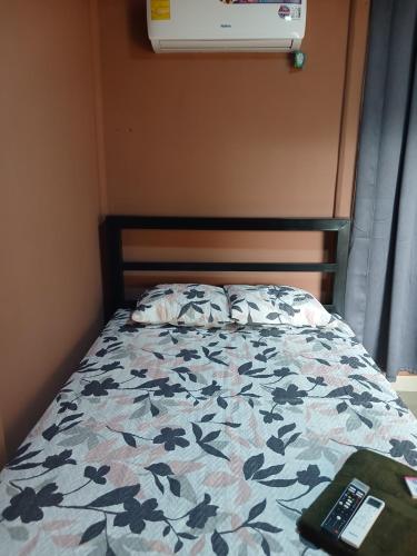 a bed with a flowered comforter with a laptop on it at Cabinas El Mirador in Canoas