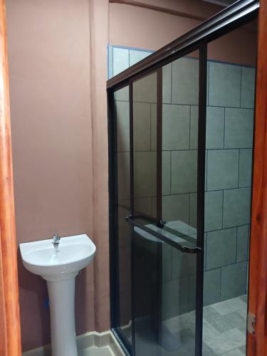 a bathroom with a sink and a glass shower at Cabinas El Mirador in Canoas