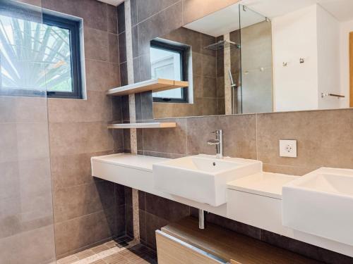 a bathroom with two sinks and a mirror at Choisy Les Bains by LOV Mauritius in Mont Choisy
