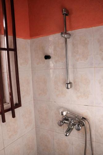a shower in a bathroom with a shower head at Rico Home Stay in Nkotunsi