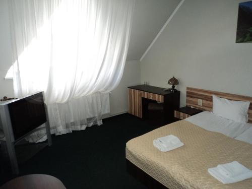 a hotel room with a bed and a window at Hotel Restaurant Vizit in Truskavets