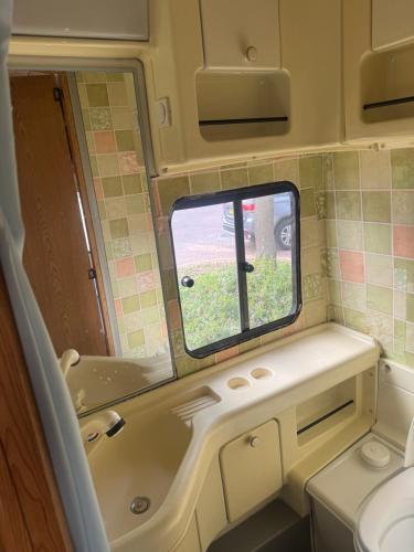a bathroom with a tub and a toilet and a window at Caravans through the nature in Mikhmoret