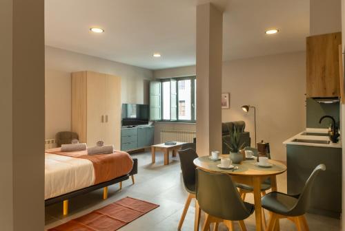 a bedroom with a bed and a table and chairs at Apartamentos Villa De Comillas in Comillas