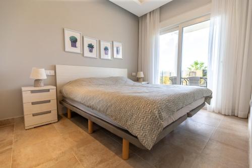 a bedroom with a bed and a large window at Nicolas in Casas Devesa
