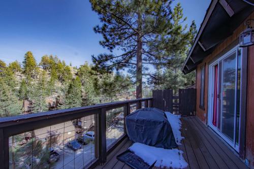 a balcony with a chair and a view of the woods at Tramway Haus Mountain Views in Stateline