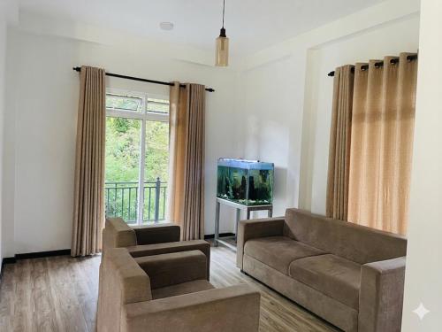 a living room with a couch and a flat screen tv at Shanuka homes in Mawanella