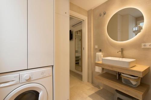 a bathroom with a washing machine and a sink at Apartamento Silleria Reyes Catolicos Centro in Granada