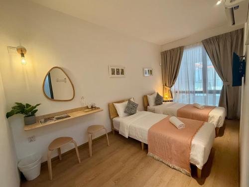 a hotel room with two beds and a mirror at ClubRock Perlis Signature Hotel in Kaki Bukit