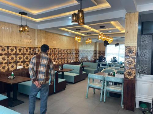 a man standing in front of a dining room at Hotel Sounsar and Restaurant in Sonāmarg