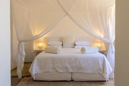 a white bed with white sheets and pillows at Aardvark Bioreserve in Ladismith