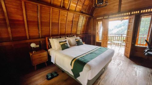 a bedroom with a bed in a room with wooden walls at Damar Langit Resort in Cisarua