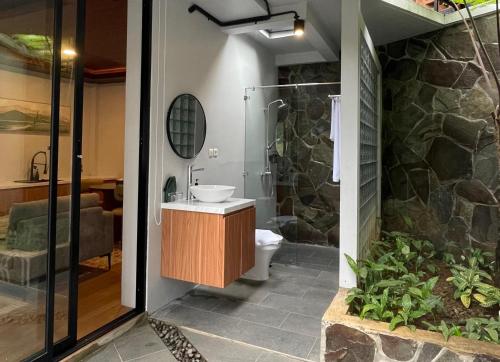 a bathroom with a shower and a toilet and a sink at Damar Langit Resort in Cisarua