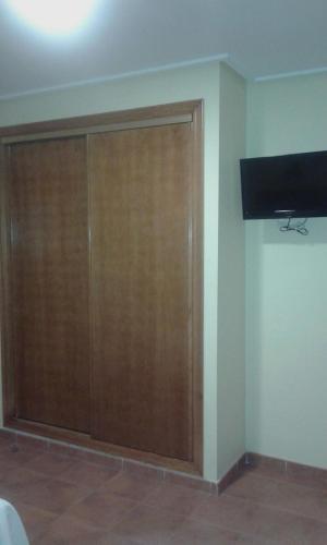 a room with a large wooden cabinet and a television at Hotel Los Molinos in Lo Pagán
