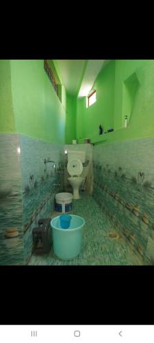 a bathroom with a toilet and a bucket in it at PeaceVibe Homestay in Uttarkāshi