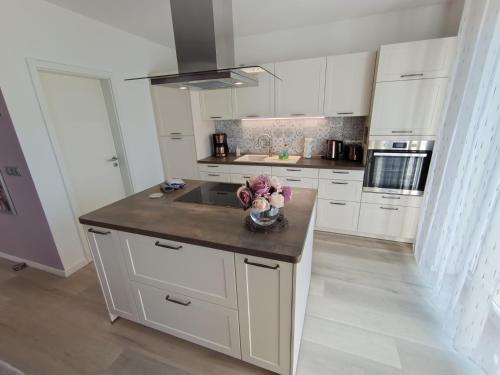 a kitchen with white cabinets and a vase of flowers on a counter at Ferienoase Müller in Lichtenhain