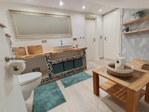 a bathroom with a sink and a toilet and a table at Ferienoase Müller in Lichtenhain