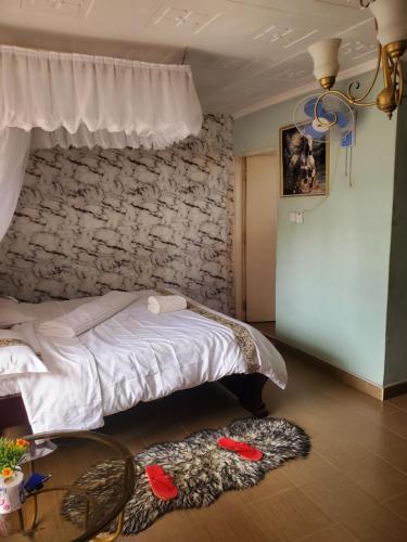 a bedroom with a bed and a stone wall at Torchys in Kisumu