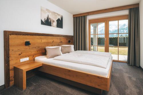 a bedroom with a bed with a wooden headboard and a window at Appartements Alexander in Fiss