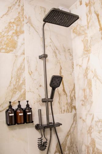 a shower in a bathroom with a black shower head at Maison Caliya in Saint-Didier-en-Velay