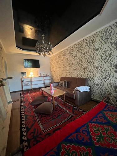 a living room with a couch and a table at Guest House URUYAT in Naryn