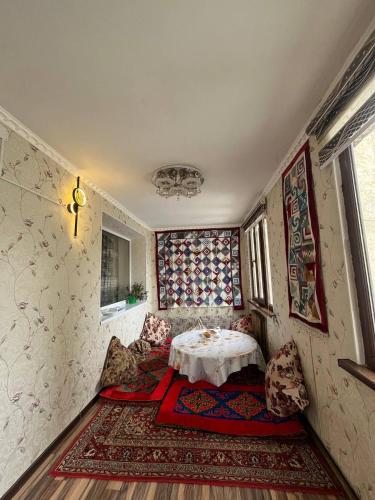 a room with a table and chairs in it at Guest House URUYAT in Naryn