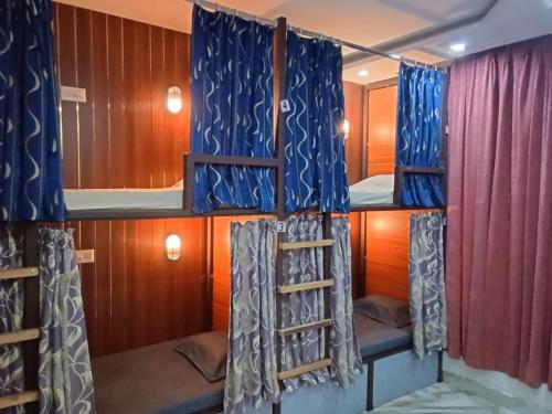 a room with two bunk beds and a ladder at Backpackers Station in Jammu