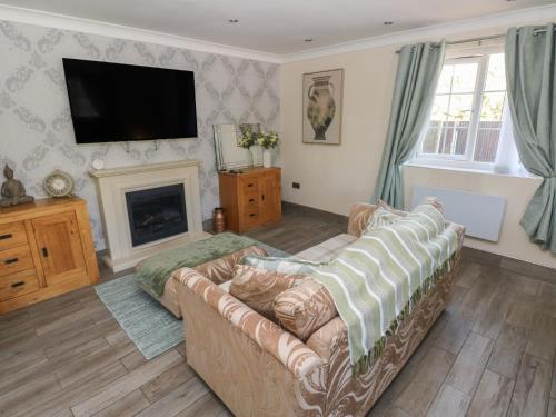 a living room with a couch and a fireplace at Annexe Meadows Farm in Swansea