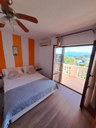 a bedroom with a bed and a large sliding glass door at Holiday House Piacun in Sućuraj