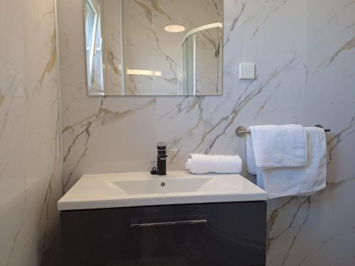 a bathroom with a sink and a mirror at Holiday House Piacun in Sućuraj