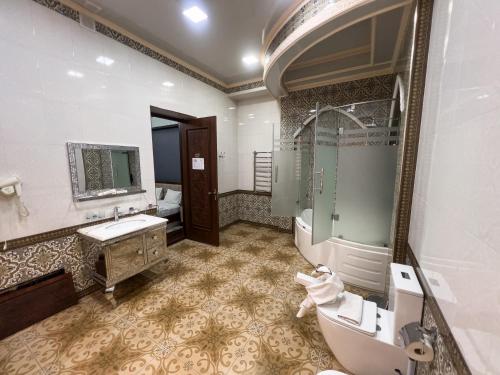 a bathroom with a sink and a shower and a toilet at Hotel Gold Begim in Fergana