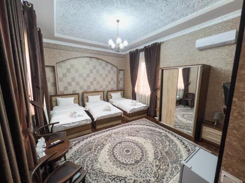a bedroom with two beds and a large mirror at Hotel Gold Begim in Fergana