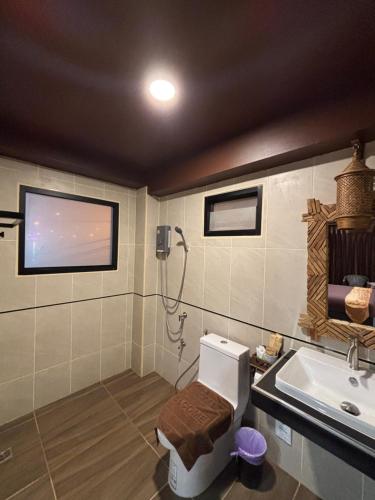 a bathroom with a shower and a toilet and a sink at Phoenix Room in Ban Tha Samet (1)