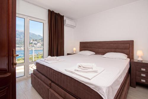 a bedroom with a large bed and a large window at Open Sea Apartments in Utjeha