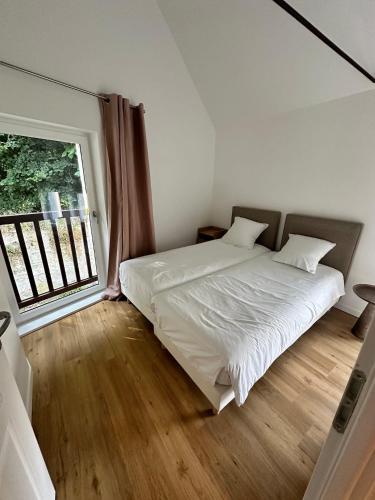 a bedroom with a bed and a large window at Duplex des montains in Loches