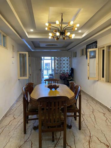 a dining room with a wooden table and chairs at Tatva stays in Dharmsāla