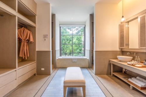 a bathroom with a sink and a toilet and a window at Flora Creek Chiang Mai in Hang Dong