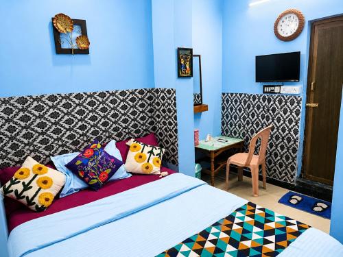 a bedroom with a bed with colorful pillows at BlueWaves in Pondicherry