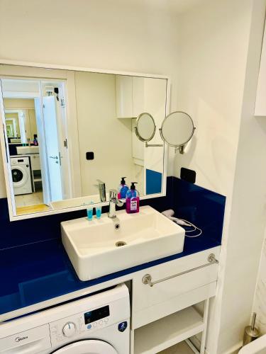 a bathroom with a white sink and a mirror at Batumi Best View in Batumi