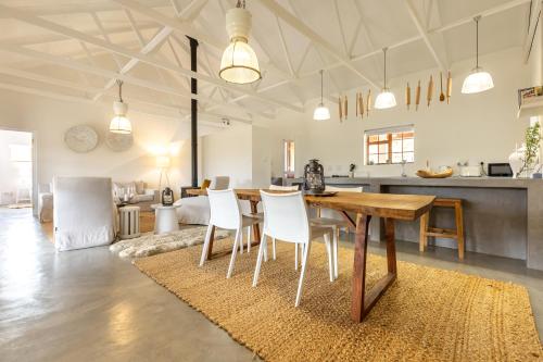 a kitchen and living room with a wooden table and chairs at Aardvark Bioreserve in Ladismith