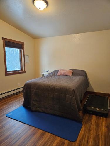 a bedroom with a bed with a blue rug at River View Upstairs Apartment in Kenai
