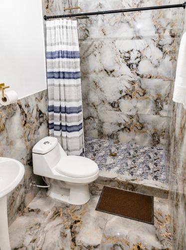 a bathroom with a toilet and a shower at Hotel Loma Linda in Ocotal
