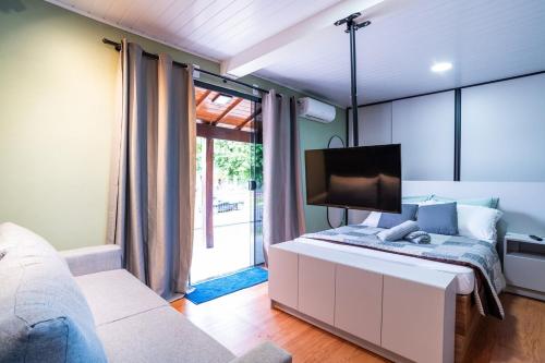 a bedroom with a bed with a tv on it at Studio c AC, Piscina e Café Novo Hamburgo in Novo Hamburgo