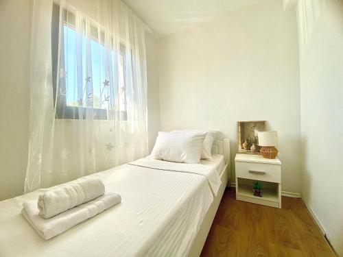 a white bedroom with a bed and a window at Villa Infinity View in Široki Brijeg
