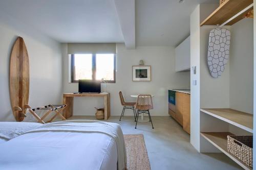 a bedroom with a bed and a desk and a table at Casa Redonda by Villas Aura - Retreat 2 in Aroeira