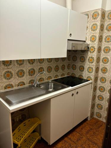 a kitchen with white cabinets and a sink at Casavacanze Zeus in Marciana Marina