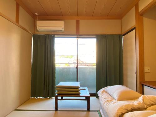 a room with a couch and a table and a window at Guest House KURA 776 Mt Fuji View and 1 min to Gekkoji Station in Fujiyoshida