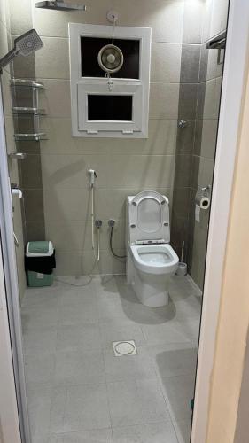 a small bathroom with a toilet and a window at صلالة مرباط in Mirbāţ