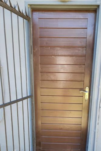 a wooden door in a room with a metal gate at Vumasky self catering in Ladysmith