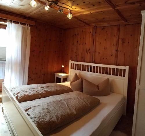 a bedroom with a large bed in a room with wooden walls at Alpin Appart Reiter- & Alpakahof in Niederthai in Niederthai