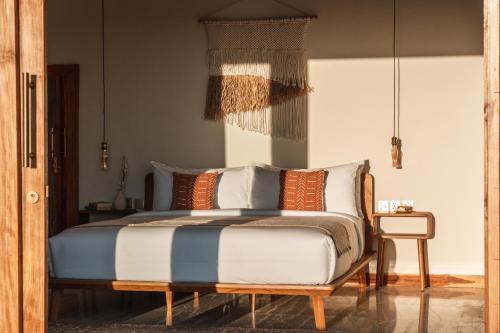 a bedroom with a bed and a chair at Salty Lotus in Uluwatu